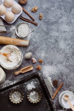 Sağlıklı Pişirme malzemeleri. Kaşık un, yemekler, yumurta, tereyağı tuz ve gri arka plan üzerinde oklava ile. Fırın arka plan çerçeve. Üstten görünüm, kopya alanı.