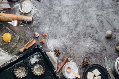 Sağlıklı Pişirme malzemeleri. Kaşık un, yemekler, yumurta, tereyağı tuz ve gri arka plan üzerinde oklava ile. Fırın arka plan çerçeve. Üstten görünüm, kopya alanı.