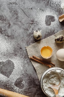 Sağlıklı Pişirme malzemeleri. Un, oklava, yumurta ve kalp şekli mutfak gri mutfak masasının üzerinde arka plan. Üstten görünüm Sevgililer günü yemek pişirmek için. Kopya alanı.
