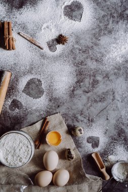 Sağlıklı Pişirme malzemeleri. Un, oklava, yumurta ve kalp şekli mutfak gri mutfak masasının üzerinde arka plan. Üstten görünüm Sevgililer günü yemek pişirmek için. Kopya alanı.