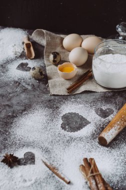 Sağlıklı Pişirme malzemeleri. Un, oklava, yumurta ve kalp şekli mutfak gri mutfak masasının üzerinde arka plan. Üstten görünüm Sevgililer günü yemek pişirmek için. Kopya alanı.