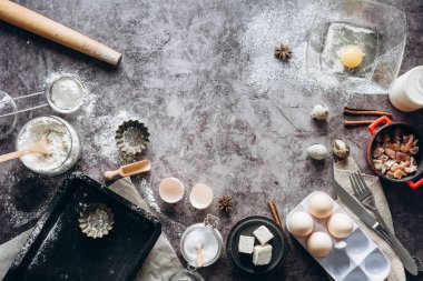 Sağlıklı Pişirme malzemeleri. Kaşık un, yemekler, yumurta, tereyağı tuz ve gri arka plan üzerinde oklava ile. Fırın arka plan çerçeve. Üstten görünüm, kopya alanı.