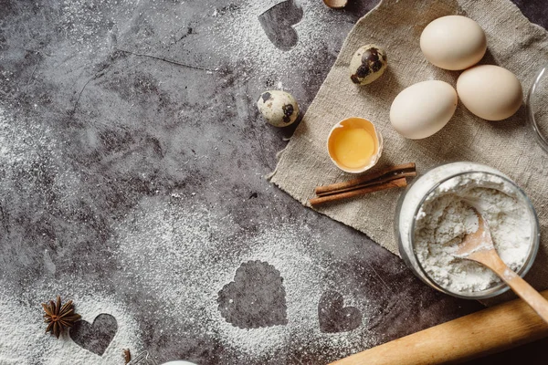 Sağlıklı Pişirme malzemeleri. Un, oklava, yumurta ve kalp şekli mutfak gri mutfak masasının üzerinde arka plan. Üstten görünüm Sevgililer günü yemek pişirmek için. Kopya alanı.