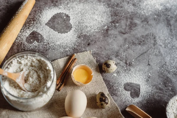 Sağlıklı Pişirme malzemeleri. Un, oklava, yumurta ve kalp şekli mutfak gri mutfak masasının üzerinde arka plan. Üstten görünüm Sevgililer günü yemek pişirmek için. Kopya alanı.