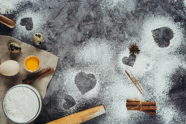Sağlıklı Pişirme malzemeleri. Un, oklava, yumurta ve kalp şekli mutfak gri mutfak masasının üzerinde arka plan. Üstten görünüm Sevgililer günü yemek pişirmek için. Kopya alanı.