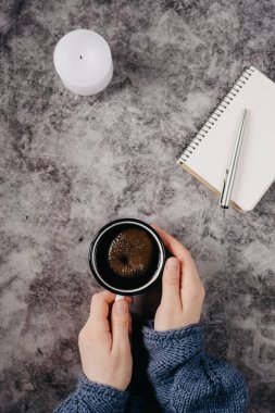 El kahve mum, defter, kalem ile gri tabloda tutar. Kış konsepti. Düz yatıyordu, en iyi görünümü.