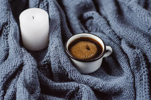 Kış veya sonbahar rahat kavramı. Fincan kahve ve mavi örgü kazak üzerine de mum. Düz yatıyordu, en iyi görünümü.