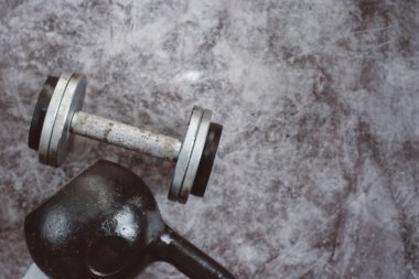 Fitness veya vücut geliştirme kavramı arka plan. Eski demir dumbell ve spor salonunda gri, beton zemin üzerinde Kettlebell. Üstten görünüm. Healthz yaşam tarzı.