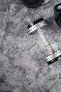 Fitness veya vücut geliştirme kavramı arka plan. Eski demir dumbell ve spor salonunda gri, beton zemin üzerinde Kettlebell. Üstten görünüm. Healthz yaşam tarzı.