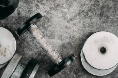 Fitness veya vücut geliştirme kavramı arka plan. Eski demir dumbell ve spor salonunda gri, beton zemin üzerinde Kettlebell. Üstten görünüm. Healthz yaşam tarzı.