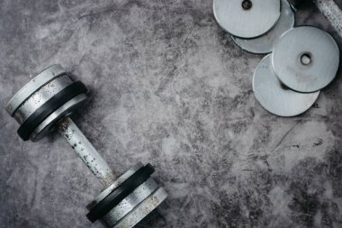 Fitness veya vücut geliştirme kavramı arka plan. Eski demir halter salonunda gri, beton zemin üzerinde. Üstten görünüm. Healthz yaşam tarzı.
