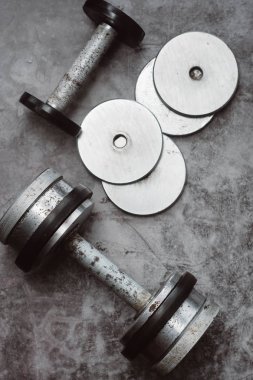 Fitness veya vücut geliştirme kavramı arka plan. Eski demir halter salonunda gri, beton zemin üzerinde. Üstten görünüm. Healthz yaşam tarzı.