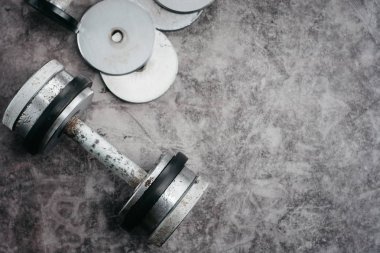 Fitness veya vücut geliştirme kavramı arka plan. Eski demir halter salonunda gri, beton zemin üzerinde. Üstten görünüm. Healthz yaşam tarzı.