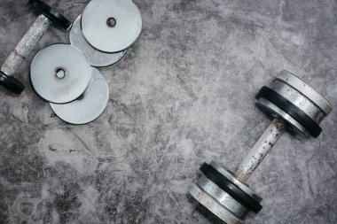 Fitness veya vücut geliştirme kavramı arka plan. Eski demir halter salonunda gri, beton zemin üzerinde. Üstten görünüm. Healthz yaşam tarzı.
