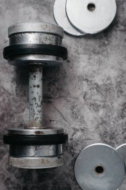 Fitness veya vücut geliştirme kavramı arka plan. Eski demir halter salonunda gri, beton zemin üzerinde. Üstten görünüm. Healthz yaşam tarzı.