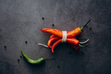 Grup, gri bir arka plan üzerinde yazıt tarafından bağlı kırmızı sıcak biber chilies biber. Metin için yer