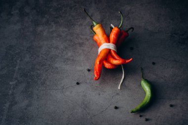 Grup, gri bir arka plan üzerinde yazıt tarafından bağlı kırmızı sıcak biber chilies biber. Metin için yer