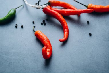 Grup, gri bir arka plan üzerinde yazıt tarafından bağlı kırmızı sıcak biber chilies biber. Metin için yer