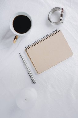 Fincan kahve, defter kalem, saat, mum ile yatak, en iyi görünüm. Kadın giyim. Düz yatıyordu, rahat kavramı