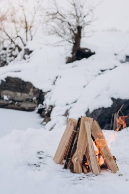 Kampı ateş içinde kış saati, donmuş göl arka planı kar tarafından çevrelenmiş. Kavramı macera aktif tatiller spor hiking açık 