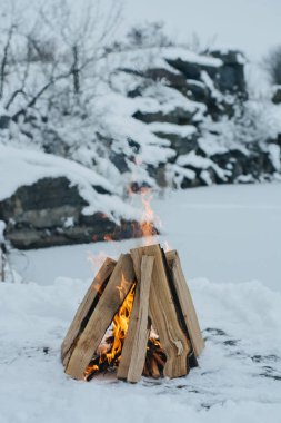 Kampı ateş içinde kış saati, donmuş göl arka planı kar tarafından çevrelenmiş. Kavramı macera aktif tatiller spor hiking açık 