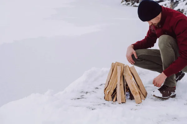 Young Man Kindling Firewood Winter Time Frozen Lake Adventure Active — Stock Photo, Image
