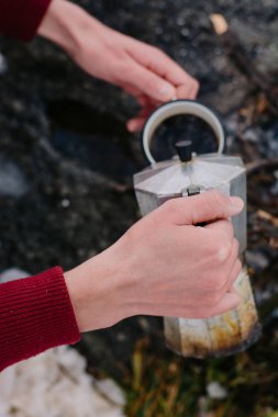 Seyahat adam oturur camp yakınındaki içinde bir kış ateş zaman ve kendisi sıcak kahve dökülen. Kavramı macera aktif tatiller açık. Kış kamp