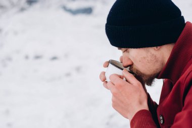 Sakallı adam kahve içiyor bir kış zamanında. Kavramı macera aktif tatiller spor hiking açık. Kış kamp