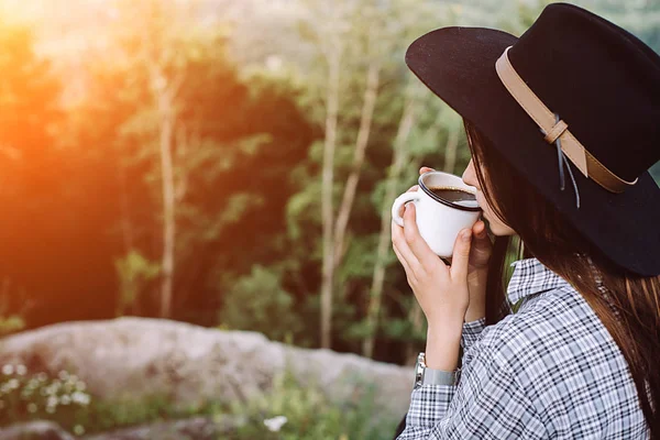 帽子の美しい少女は 山と日の出を楽しんでの上にコーヒーを飲みます 概念冒険アクティブな休暇屋外山中 夏のキャンプ — ストック写真