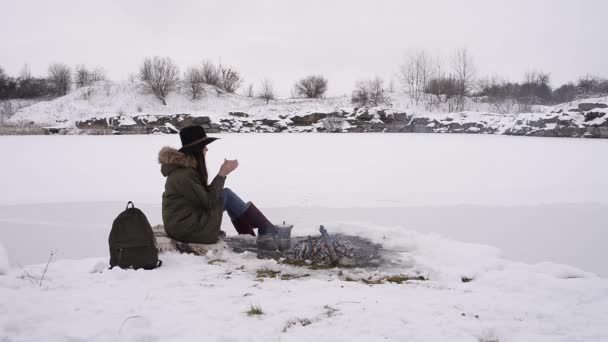 Girl Hat Sits Camp Fire Cup Hot Coffee Winter Time — Stock Video