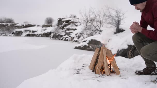 Hombre Calentando Sus Manos Una Fogata Invierno Rodeado Nieve Contra — Vídeos de Stock