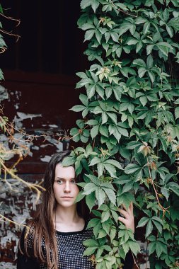 Güzel genç kadın, yeşil bir arka plana dayanır portre yaz aylarında açık bırakır. Yeşil yaprakları doğanın keyfini kız