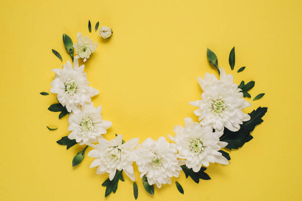 Creative flowers composition. Wreath made of white flowers on yellow background. Mothers day, womens day, spring concept. Flat lay, top view, copy space