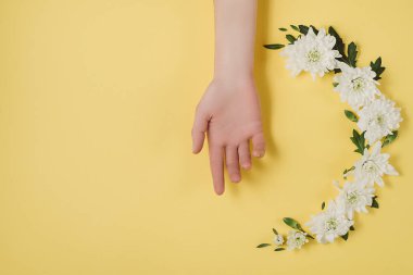 Yaratıcı çiçek kompozisyon. Kadın el ve çelenk çiçek Sarı zemin üzerine beyaz. Düz yatıyordu, en iyi görünüm çok az Festival yaz çiçek kavramı.
