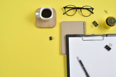 Düz yatıyordu, en iyi görünümü office tablo Resepsiyon. Çalışma alanı boş klibi kurulu, büro malzemeleri, kalem, kaktüs, kahve fincanı bir ahşap stand ve Sarı zemin üzerine gözlük ile. Blog kavramı