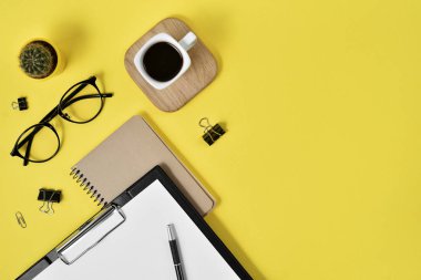 Düz yatıyordu, en iyi görünümü office tablo Resepsiyon. Çalışma alanı boş klibi kurulu, büro malzemeleri, kalem, kaktüs, kahve fincanı bir ahşap stand ve Sarı zemin üzerine gözlük ile. Blog kavramı