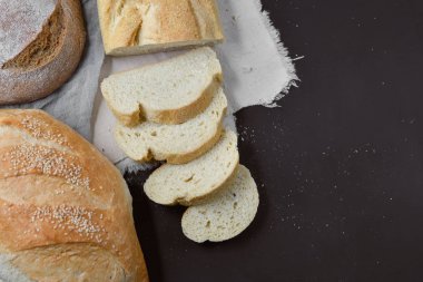 Fırın ekmek üreticileri - taze ev yapımı ekmek Siyah Kara tahta zemin üzerine dilimlenmiş. Düz yatıyordu, en iyi görünüm, metniniz için kopya alanı