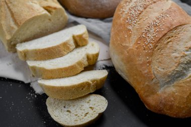 Fırın ekmek üreticileri - taze ev yapımı ekmek Siyah Kara tahta zemin üzerine dilimlenmiş. Düz yatıyordu, en iyi görünüm, metniniz için kopya alanı