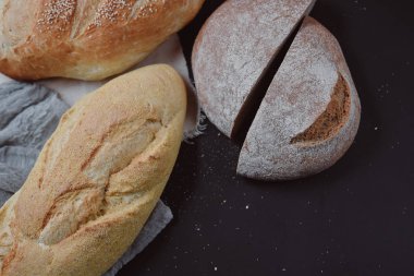 Fırın ekmek üreticileri - altın rustik huysuz somun ekmek Siyah Kara tahta arka plan üzerinde. Düz yatıyordu, en iyi görünüm, metniniz için kopya alanı