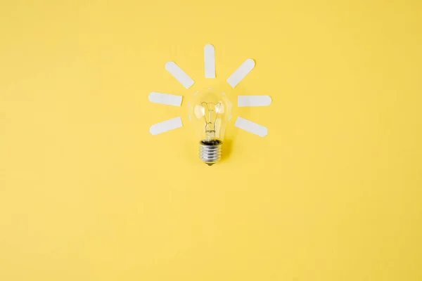 Creative flat lay concept top view of light bulb on yellow color paper background. Concept brainstorming and new idea