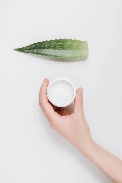 Vista ritagliata delle mani femminili con crema biologica e foglia di aloe vera su sfondo bianco. Layout piatto, vista dall'alto, spazio di copia, stile minimale. Concetto bellezza . — Foto Stock