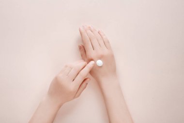Kadın bej arka planda kopya alanı ile kozmetik krem losyon ile elini nemlendirici. Konsept şablon kadınsı blog, güzellik kavramı
