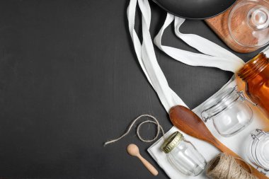 Sıfır atık kavramı. Meyve veya sebze, keten masa örtüsü, cam kavanoz, bardak ve siyah arka planda ahşap kaşık için yeniden kullanılabilir, geri dönüştürülmüş, ev yapımı çanta üretmek.