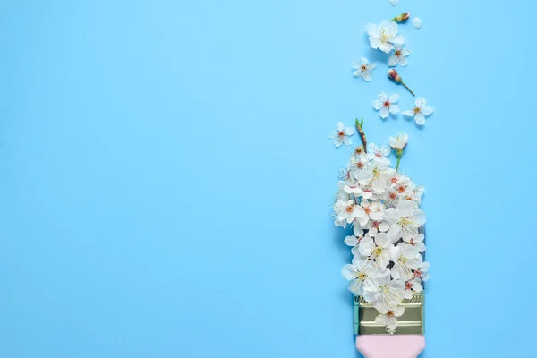 Creative flower arrangement. Paintbrush With Blossoms on pastel blue background. Minimal nature flat lay. Top view, copy space