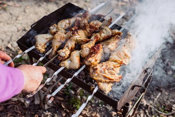 Foto de primer plano de la parrilla de barbacoa con carne de pollo al aire libre en la hora de verano. Hombre cocinando comida en la naturaleza. Concepto aventura activo vacaciones al aire libre —  Fotos de Stock