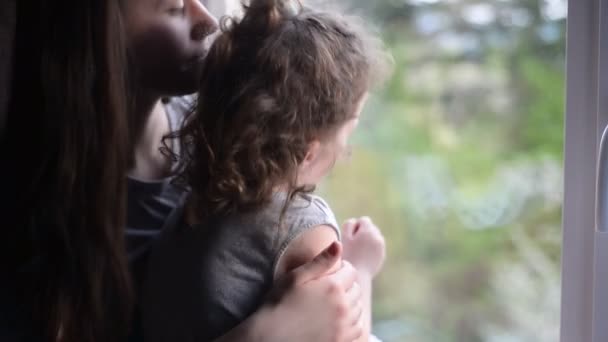 愛情のあるシングルマザーのクローズアップポートレートは 窓の近くにかわいい娘を抱きしめ 幸せな母と小さな女の子は一緒に楽しい瞬間を楽しんで楽しんで抱きしめる — ストック動画