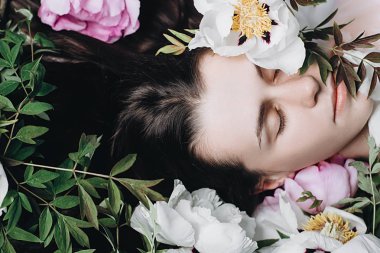 Beyaz ve mor çiçeklerle çekici beyaz bir kadının yakın çekim yatay portresi. Güzel esmer genç kız çiçeklerzevk. Kapak fikir ruh hali