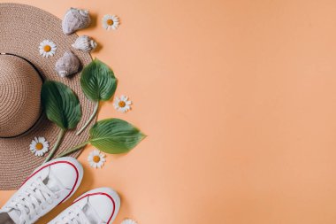Gezgin aksesuarları, tropikal yaprak, şapka, Ayakkabı ve turuncu arka plan üzerinde deniz kabuğu. Seyahat tatil konsepti. Yaz geçmişi. Düz yatıyordu, üst görünüm, kopya alanı