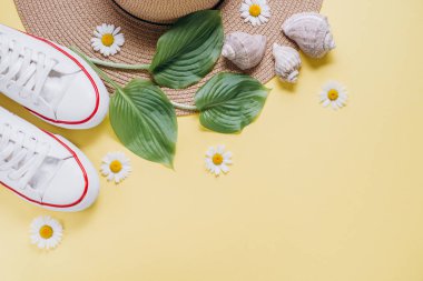 Yaz tatil konsepti düz yatıyordu. Pastel Sarı arka planda tropikal yaprak, şapka, Ayakkabı ve deniz kabuğu. Metin alanı. Yaz geçmişi