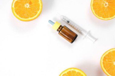 Şişe narenciye uçucu yağ ve beyaz arka plan taze sulu portakal meyve. Cilt için yüksek doz c vitamini sentetik. Düz döşeme, üst görünüm, kopyalama alanı